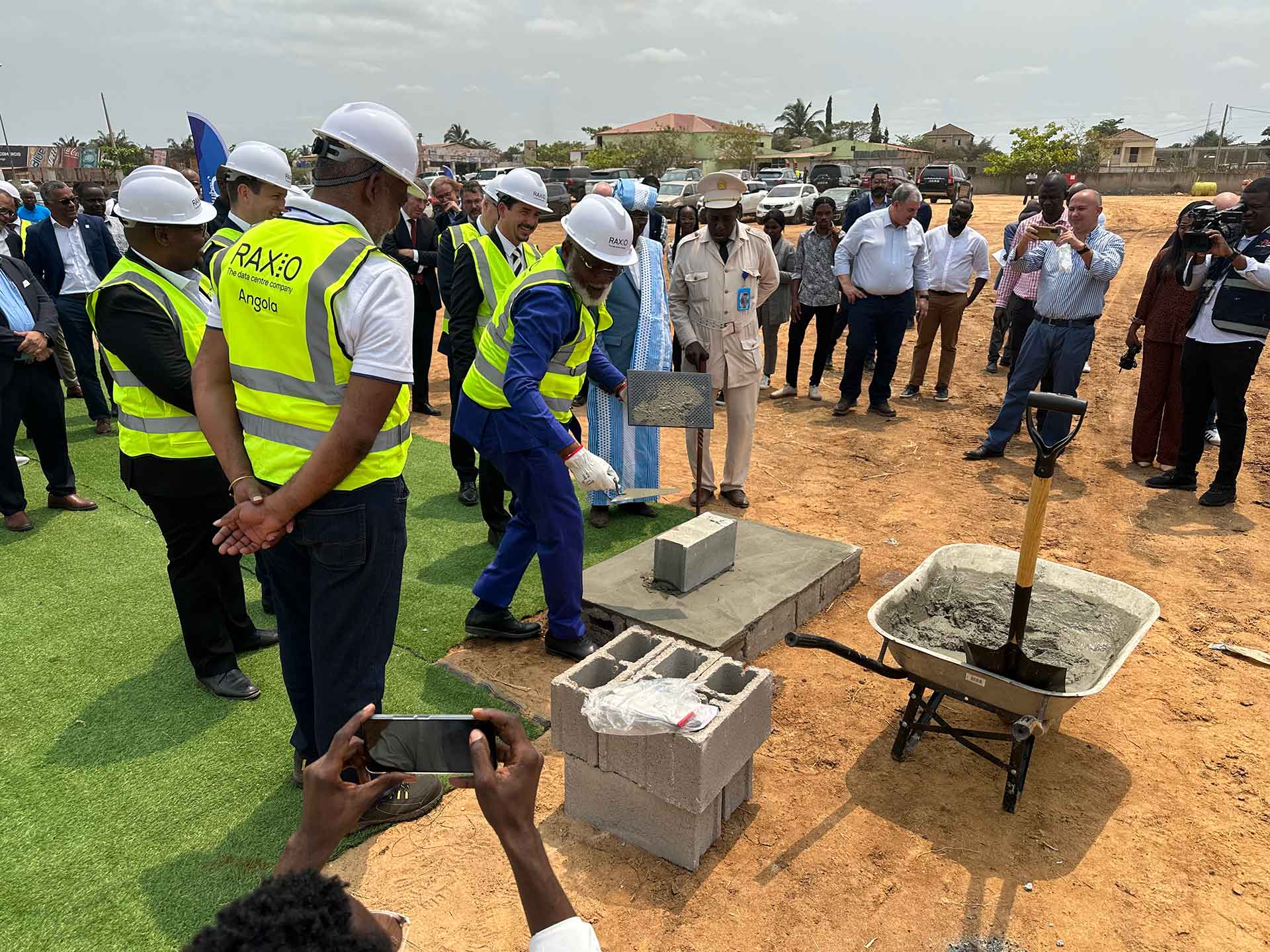 Administrador do Distrito Urbano de Cacuaco, Adão Pacheco Valentim, e Robert Mullins, CEO do Grupo Raxio assentam o primeiro tijolo na cerimônia de abertura da Raxio em Angola.